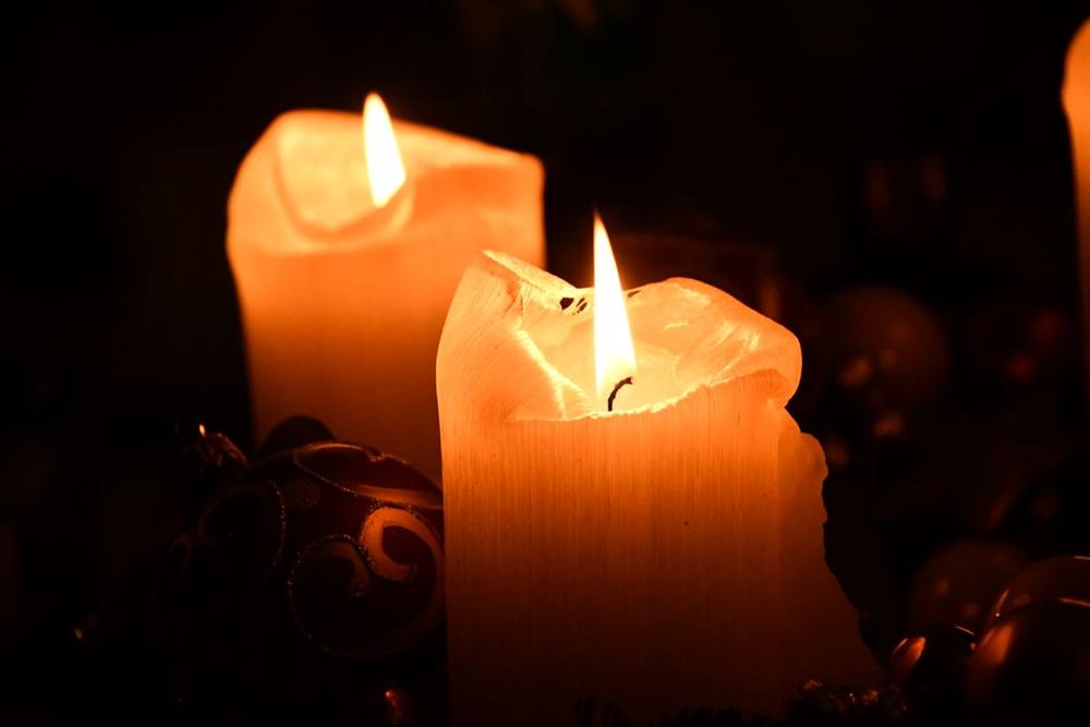 Two candles burning softly in a dark room